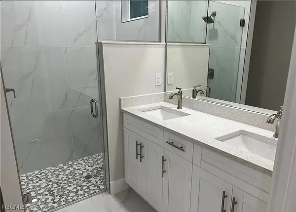 a bathroom with a sink and a mirror with shower