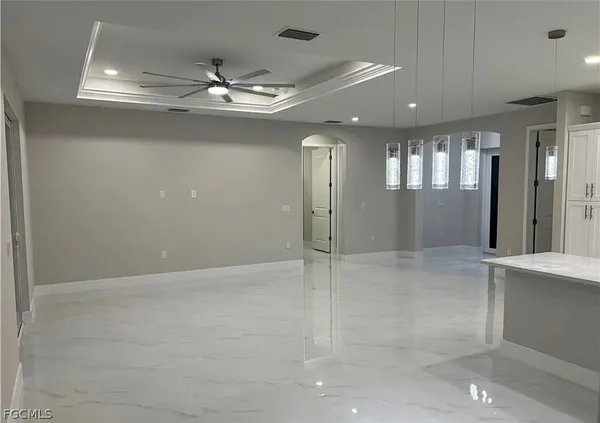 an empty room with chandelier fan