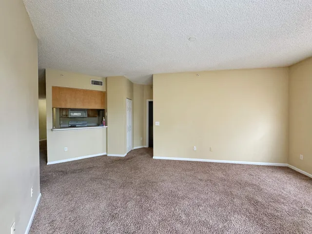 a view of an empty room with a kitchen