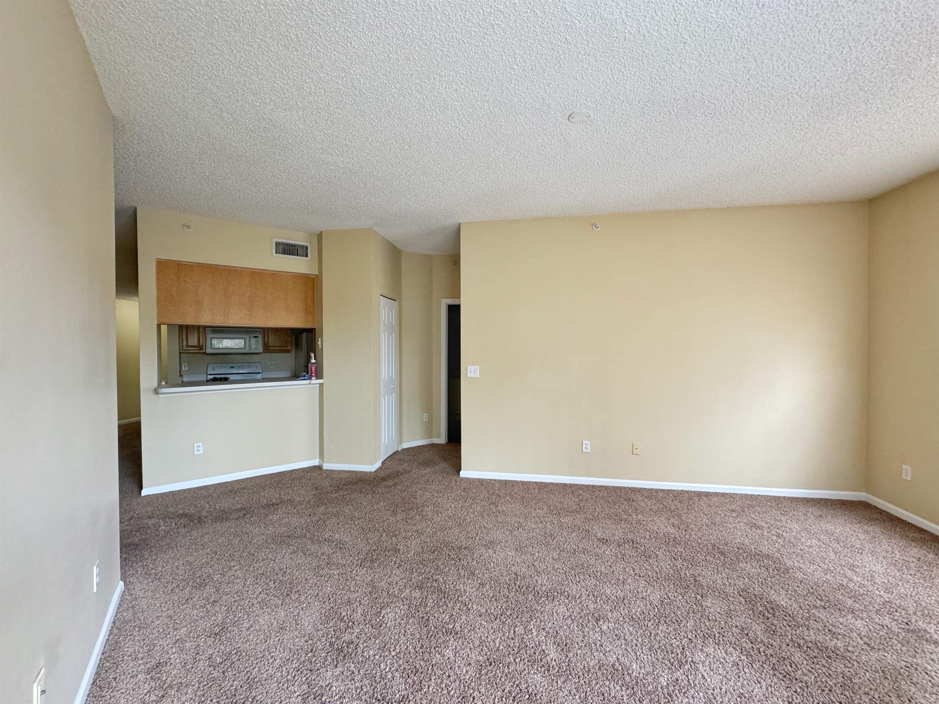 4035 Grande Vista Boulevard, Unit 201 St. Augustine, FL 32084 - Photo 5 of 28 a view of an empty room with a kitchen