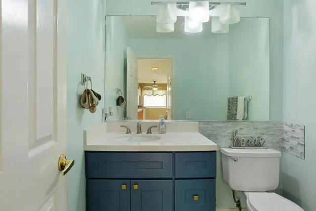 a bathroom with a sink vanity granite and toilet