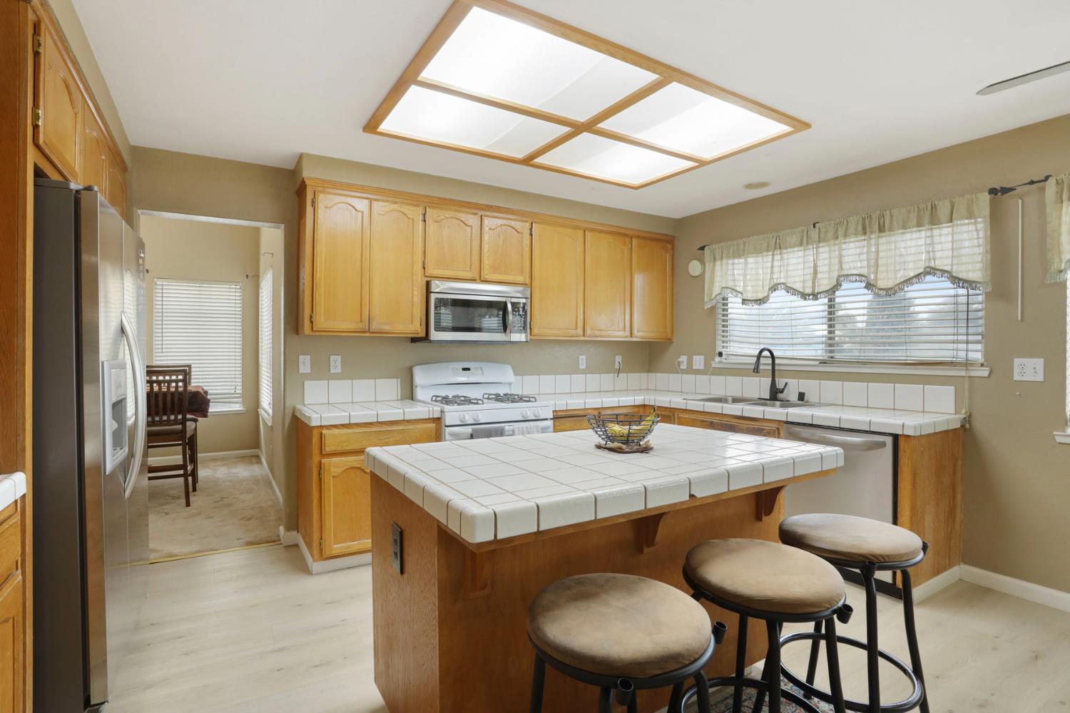 1725 Mark Mead Lane Modesto, CA 95356 - Photo 18 of 52 a kitchen with a table chairs sink and cabinets