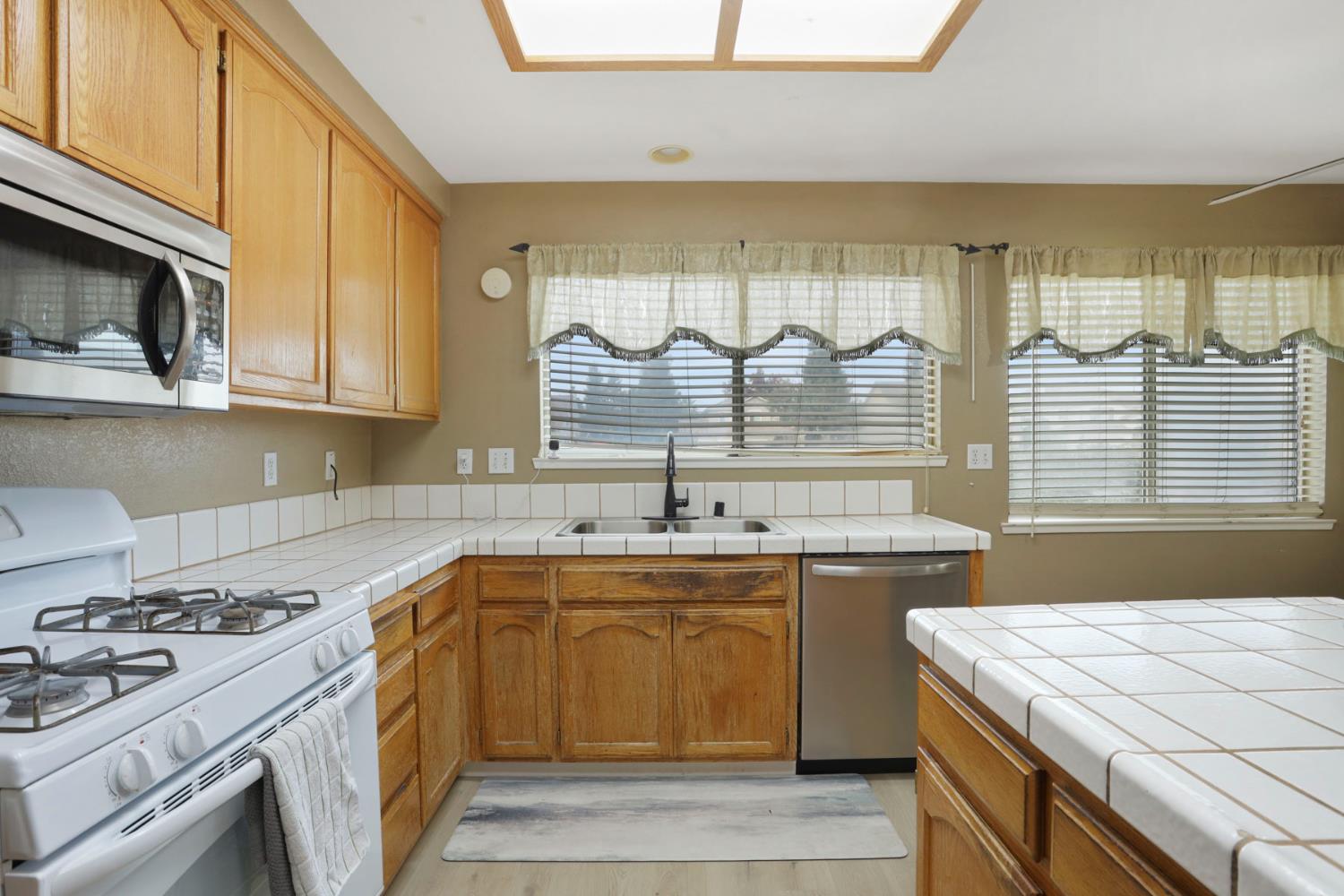 1725 Mark Mead Lane Modesto, CA 95356 - Photo 20 of 52 a kitchen with a sink stove top oven and cabinets