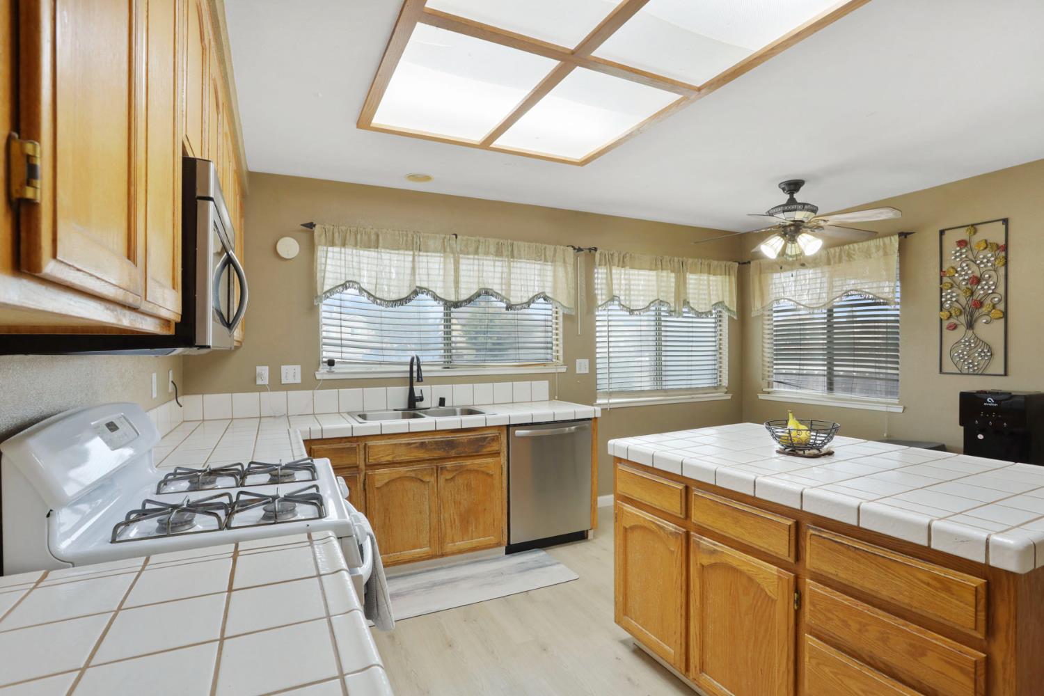 1725 Mark Mead Lane Modesto, CA 95356 - Photo 21 of 52 a kitchen with stainless steel appliances a sink stove and cabinets