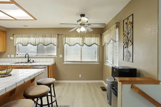 a kitchen with a table chairs sink and cabinets