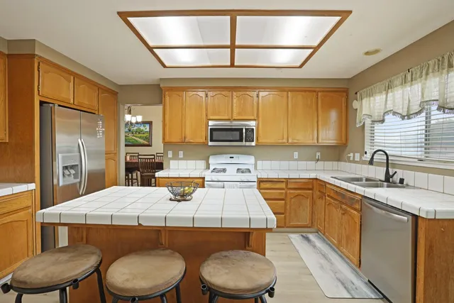a kitchen with a sink appliances cabinets and a counter top space
