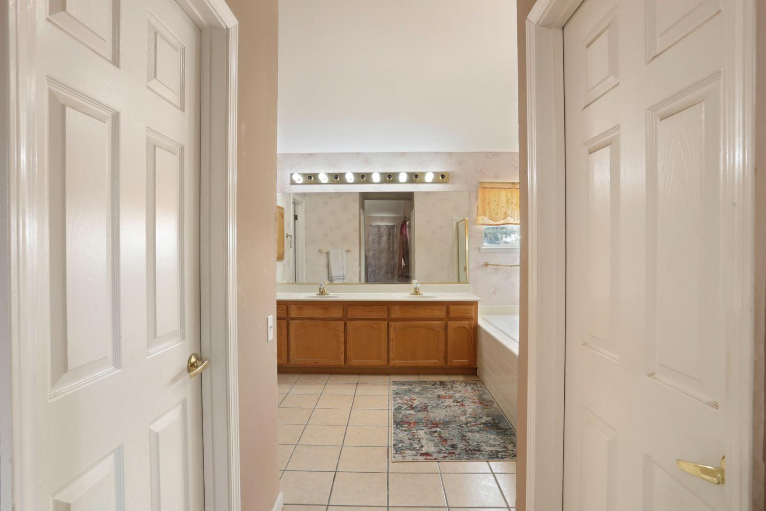 1725 Mark Mead Lane Modesto, CA 95356 - Photo 37 of 52 a bathroom with a granite countertop sink a mirror and a bathtub