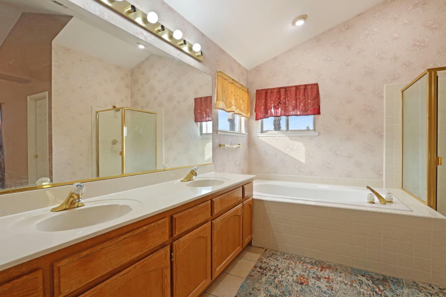 1725 Mark Mead Lane Modesto, CA 95356 - Photo 40 of 52 a bathroom with a tub sink and mirror