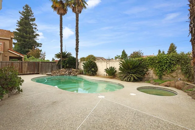 a view of a backyard with a fountain plants and palm tree