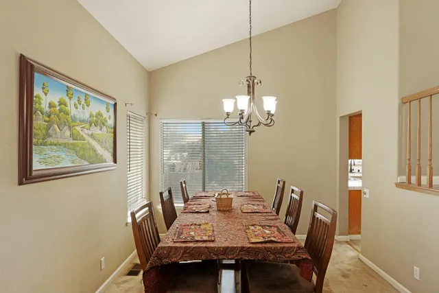 a view of a dining room with furniture a chandelier and wooden floor