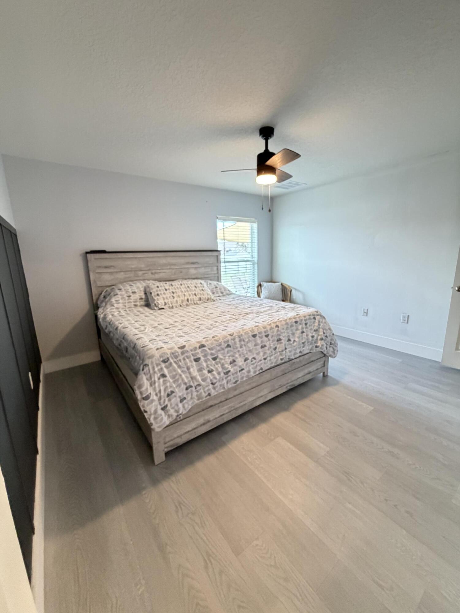 4249 Southwest Whitebread Road Port St. Lucie, FL 34953 - Photo 18 of 43 a bedroom with a bed and a ceiling fan