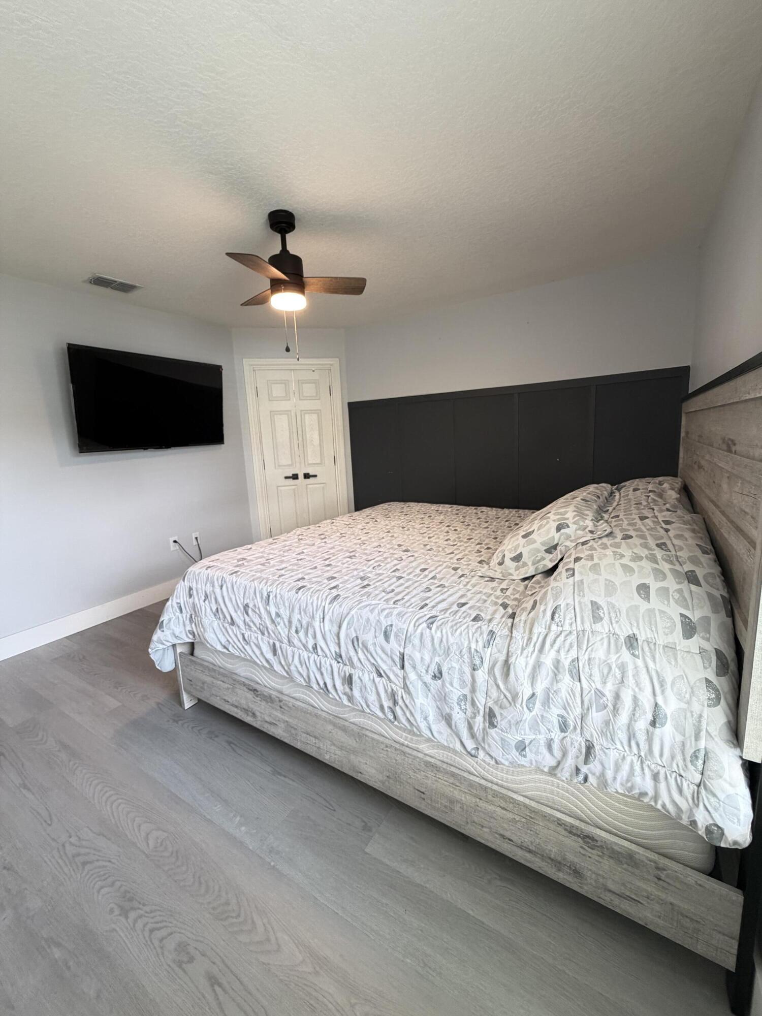 4249 Southwest Whitebread Road Port St. Lucie, FL 34953 - Photo 20 of 43 a spacious bedroom with a bed and a flat screen tv