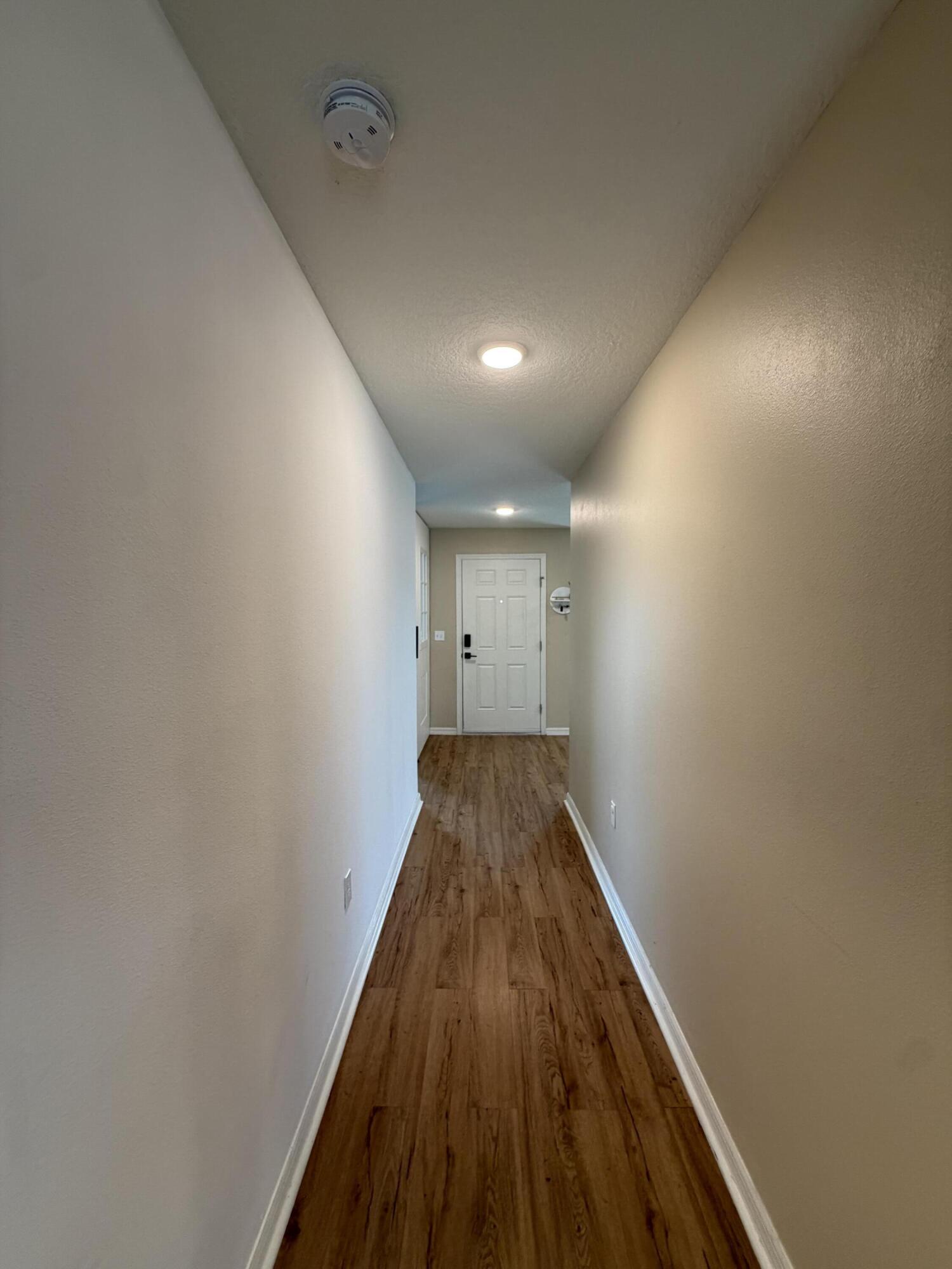 4249 Southwest Whitebread Road Port St. Lucie, FL 34953 - Photo 23 of 43 a view of a hallway with wooden floor
