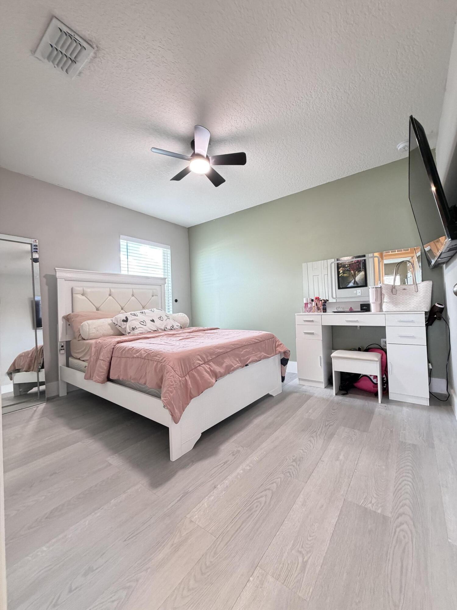 4249 Southwest Whitebread Road Port St. Lucie, FL 34953 - Photo 26 of 43 a bedroom with a bed and a chandelier