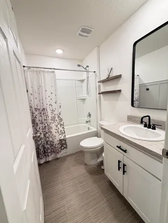 a bedroom with a bed a flat screen tv and a chandelier