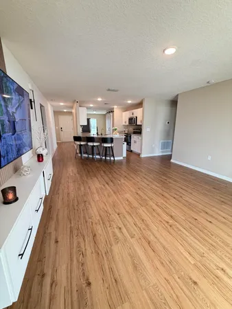 an empty room with furniture and a flat screen tv
