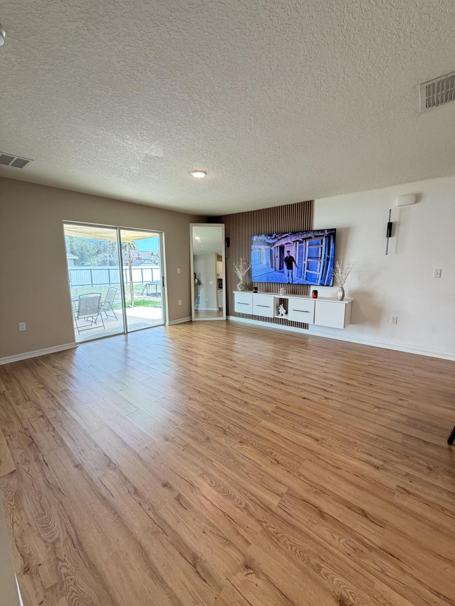4249 Southwest Whitebread Road Port St. Lucie, FL 34953 - Photo 6 of 43 a big room with wooden floor and windows