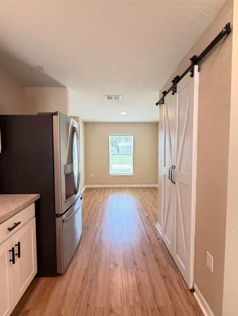 an empty room with wooden floor and windows