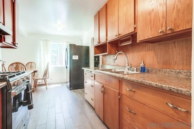 a kitchen with granite countertop a sink a stove and cabinets