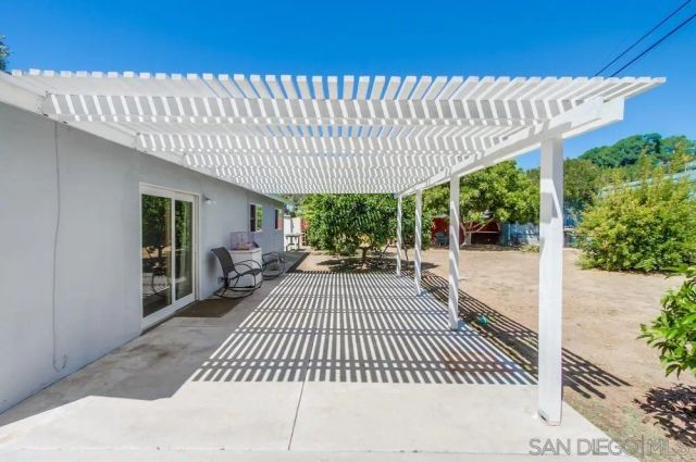 a view of a patio with table and chairs with wooden floor and fence