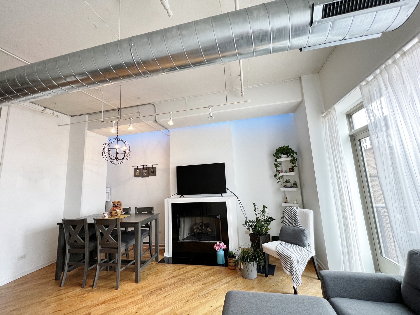 500 South Clinton Street, Unit 720 Chicago, IL 60607 - Photo 5 of 19 a living room with furniture a fireplace and a dining table with wooden floor