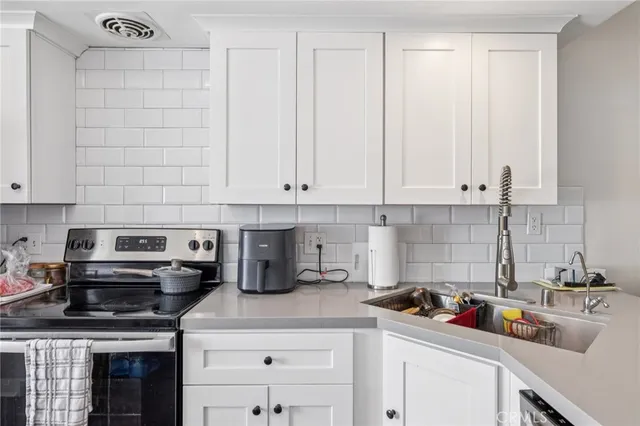a kitchen with stainless steel appliances granite countertop a sink stove and cabinets