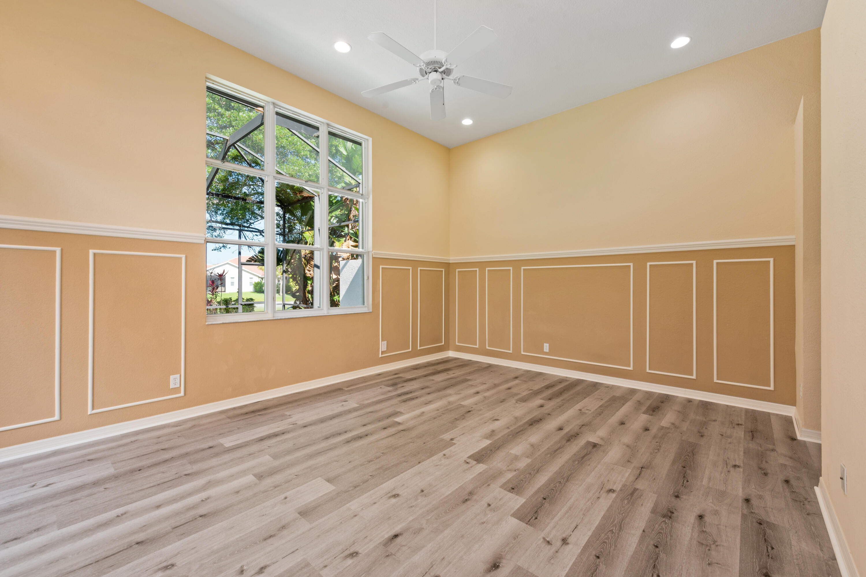 8525 Peppertree Way Naples, FL 34114 - Photo 11 of 47 an empty room with wooden floor and windows