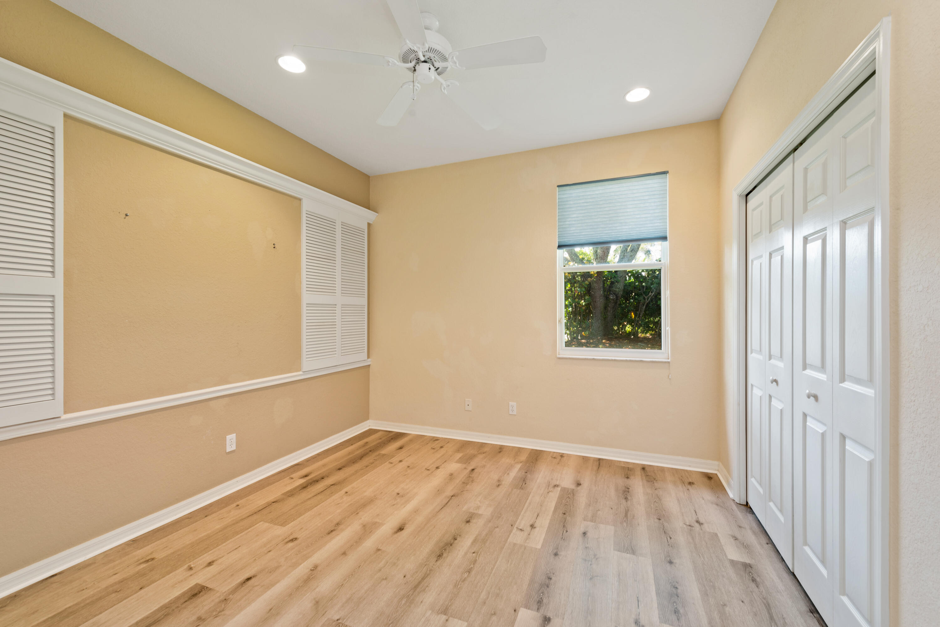 8525 Peppertree Way Naples, FL 34114 - Photo 15 of 47 a view of an empty room with wooden floor and a window