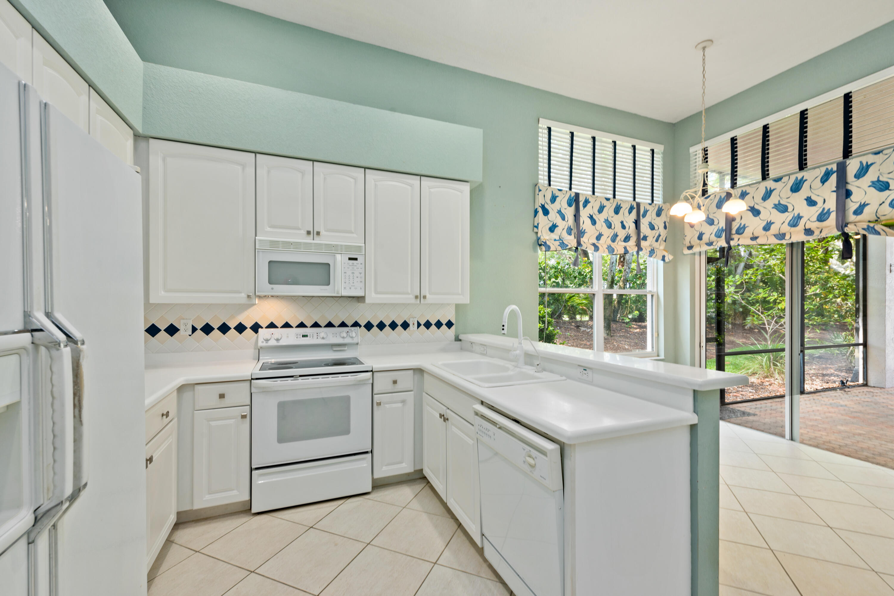 8525 Peppertree Way Naples, FL 34114 - Photo 6 of 47 a kitchen with granite countertop white cabinets and white appliances