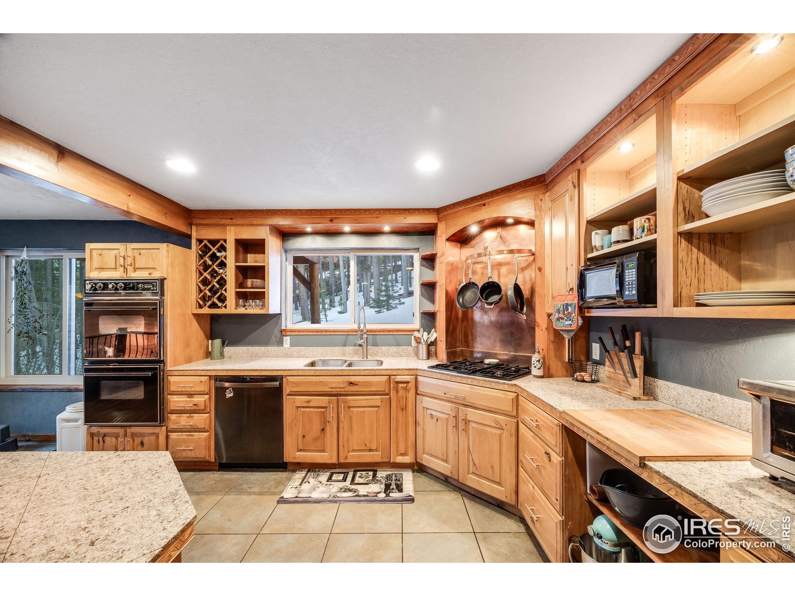 46 Apache Road Evergreen, CO 80439 - Photo 14 of 39 a kitchen with stainless steel appliances granite countertop a sink and cabinets