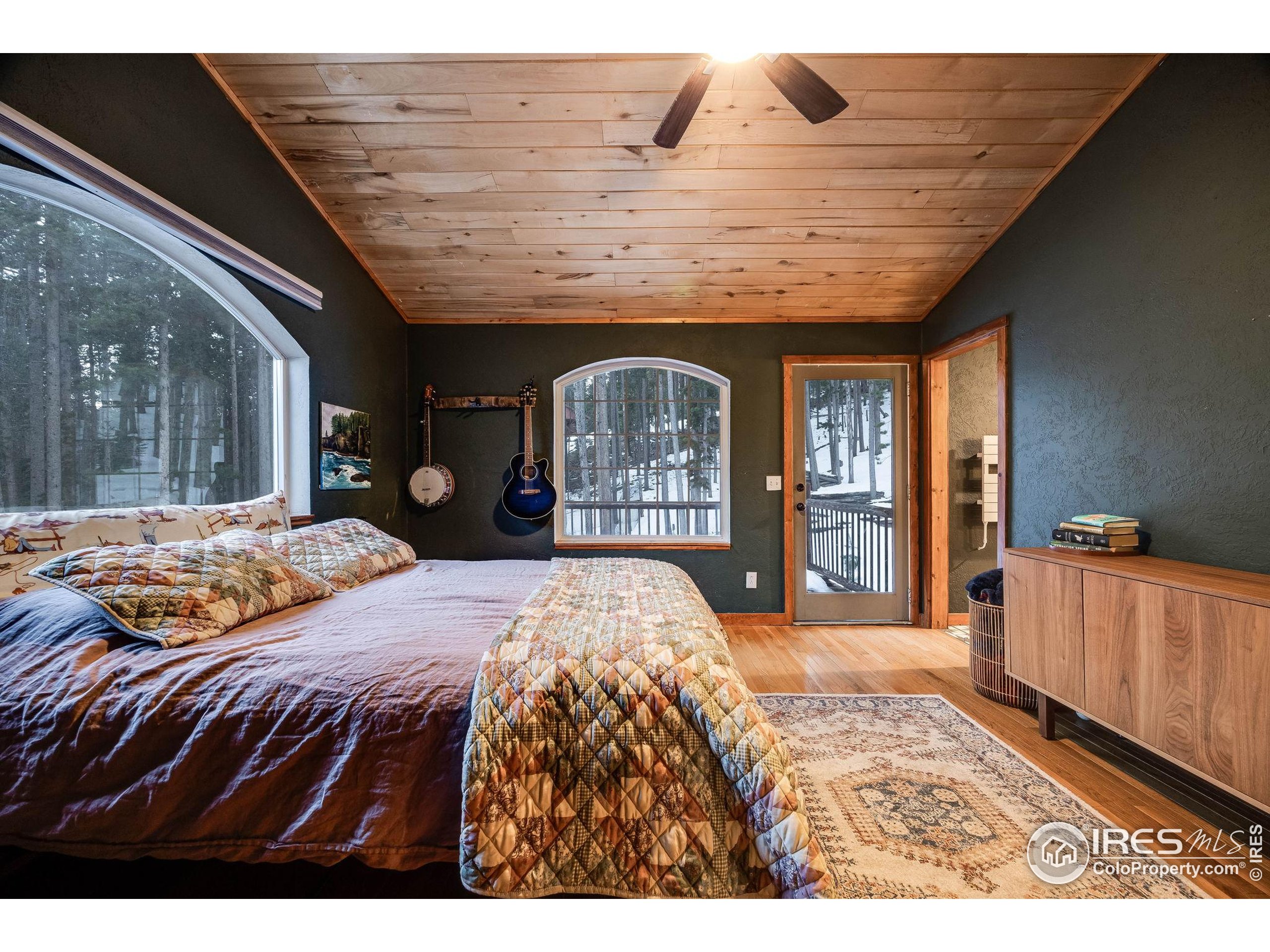 46 Apache Road Evergreen, CO 80439 - Photo 24 of 39 a bedroom with a large bed and a large window