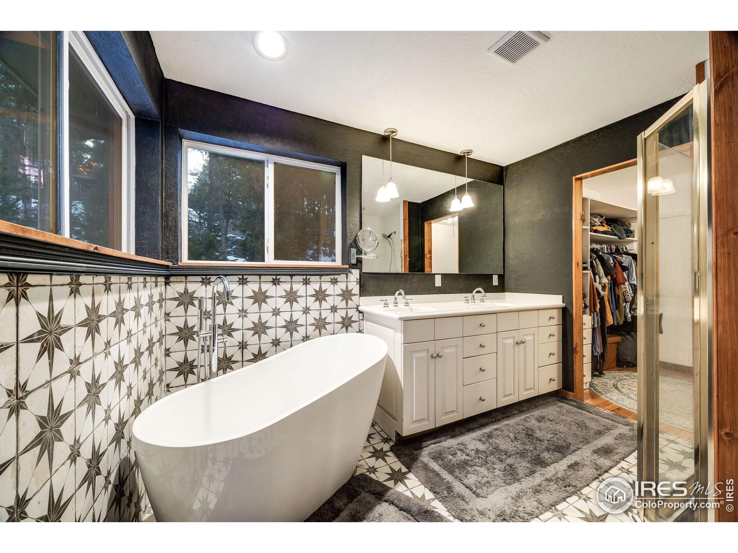 46 Apache Road Evergreen, CO 80439 - Photo 29 of 39 a bathroom with a sink a bathtub a mirror and a shower