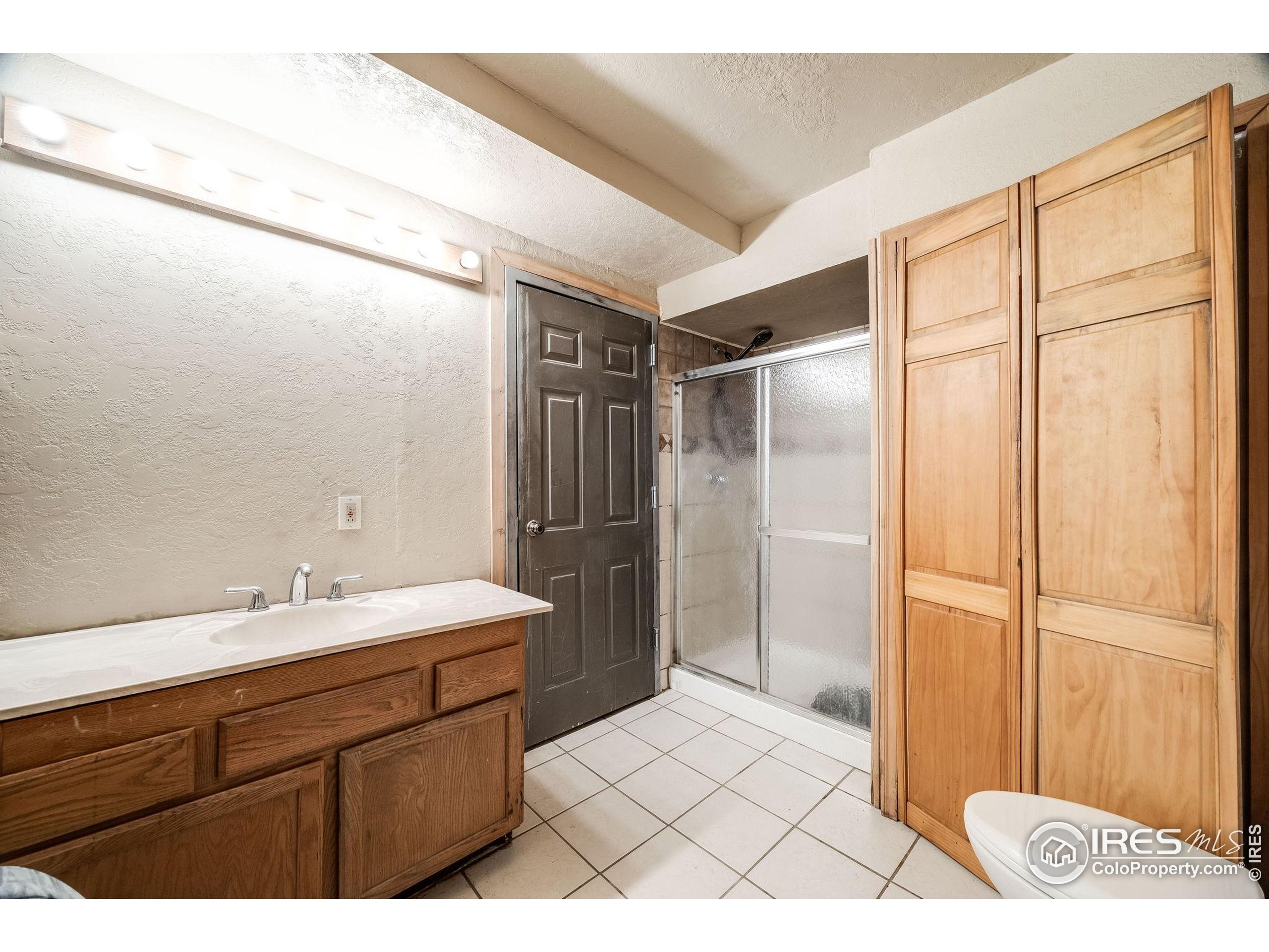46 Apache Road Evergreen, CO 80439 - Photo 33 of 39 a bathroom with a sink a mirror and a shower