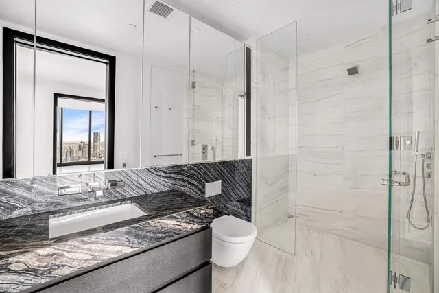 a en suite bathroom with a granite countertop sink and a mirror