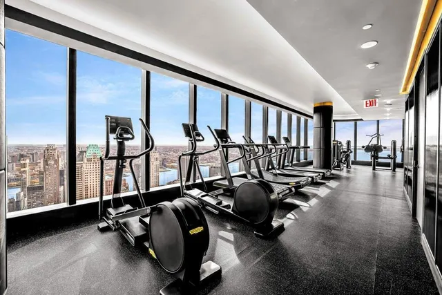 a living room with gym equipment and a large window