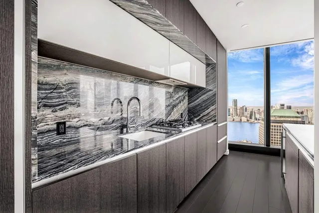 a view of an empty room with furniture and windows