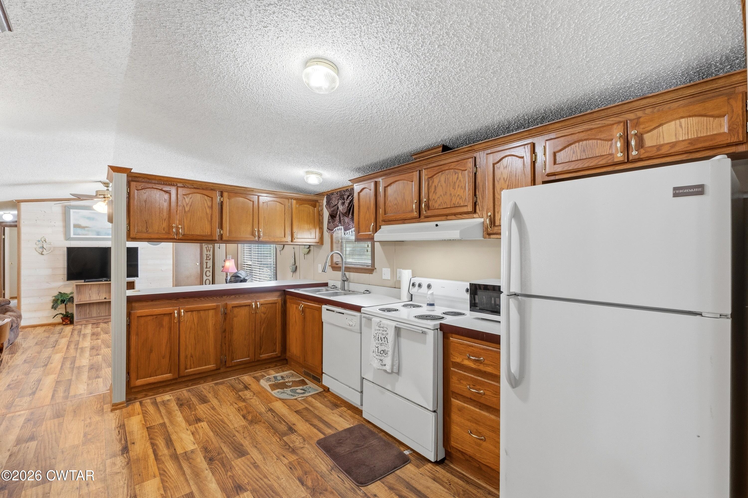 1444-1448 New Hope Road Big Sandy, TN 38221 - Photo 11 of 39 a kitchen with stainless steel appliances granite countertop a refrigerator stove top oven and sink