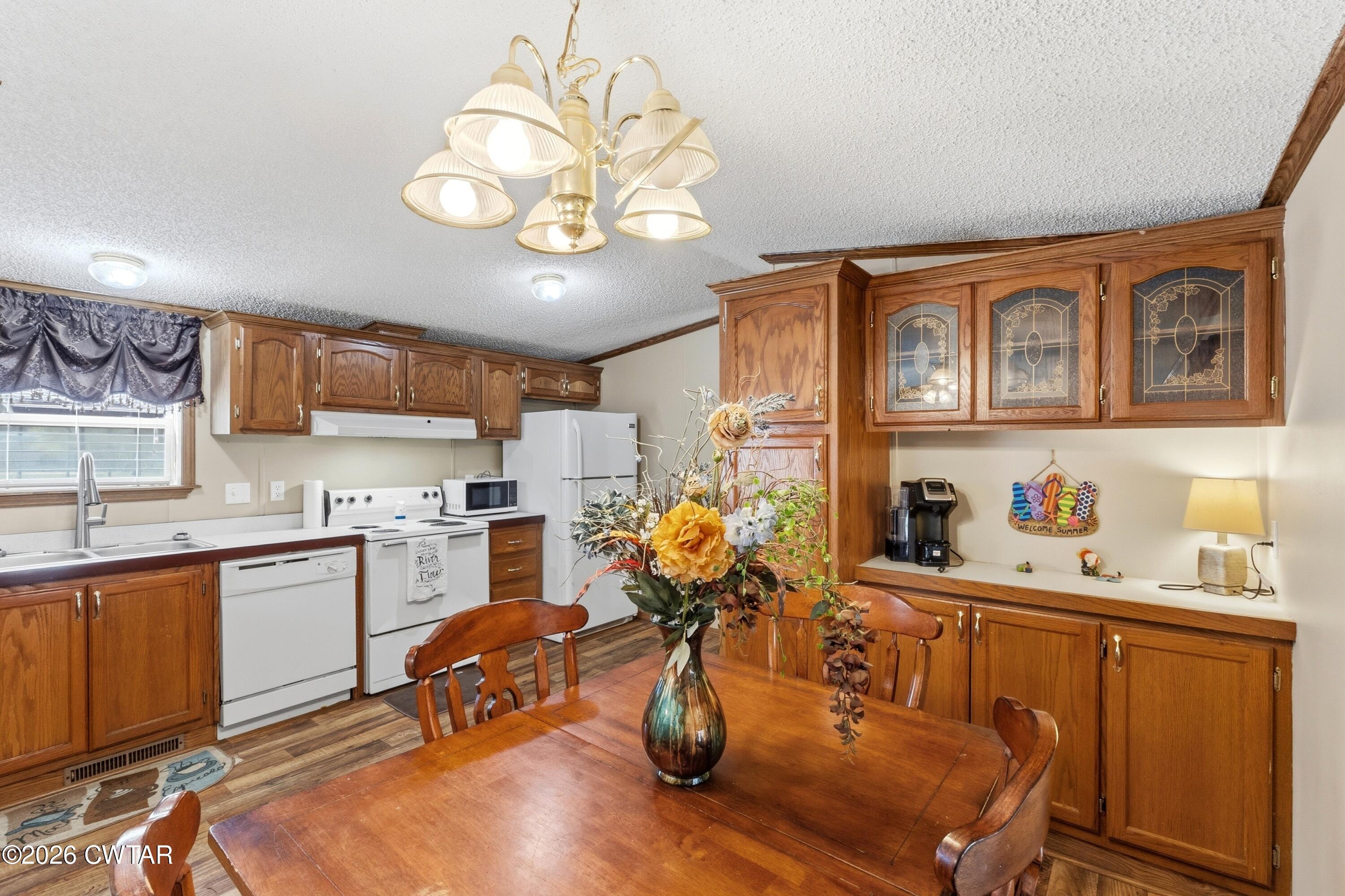 1444-1448 New Hope Road Big Sandy, TN 38221 - Photo 12 of 39 a kitchen with stainless steel appliances granite countertop a sink dishwasher and cabinets with wooden floor