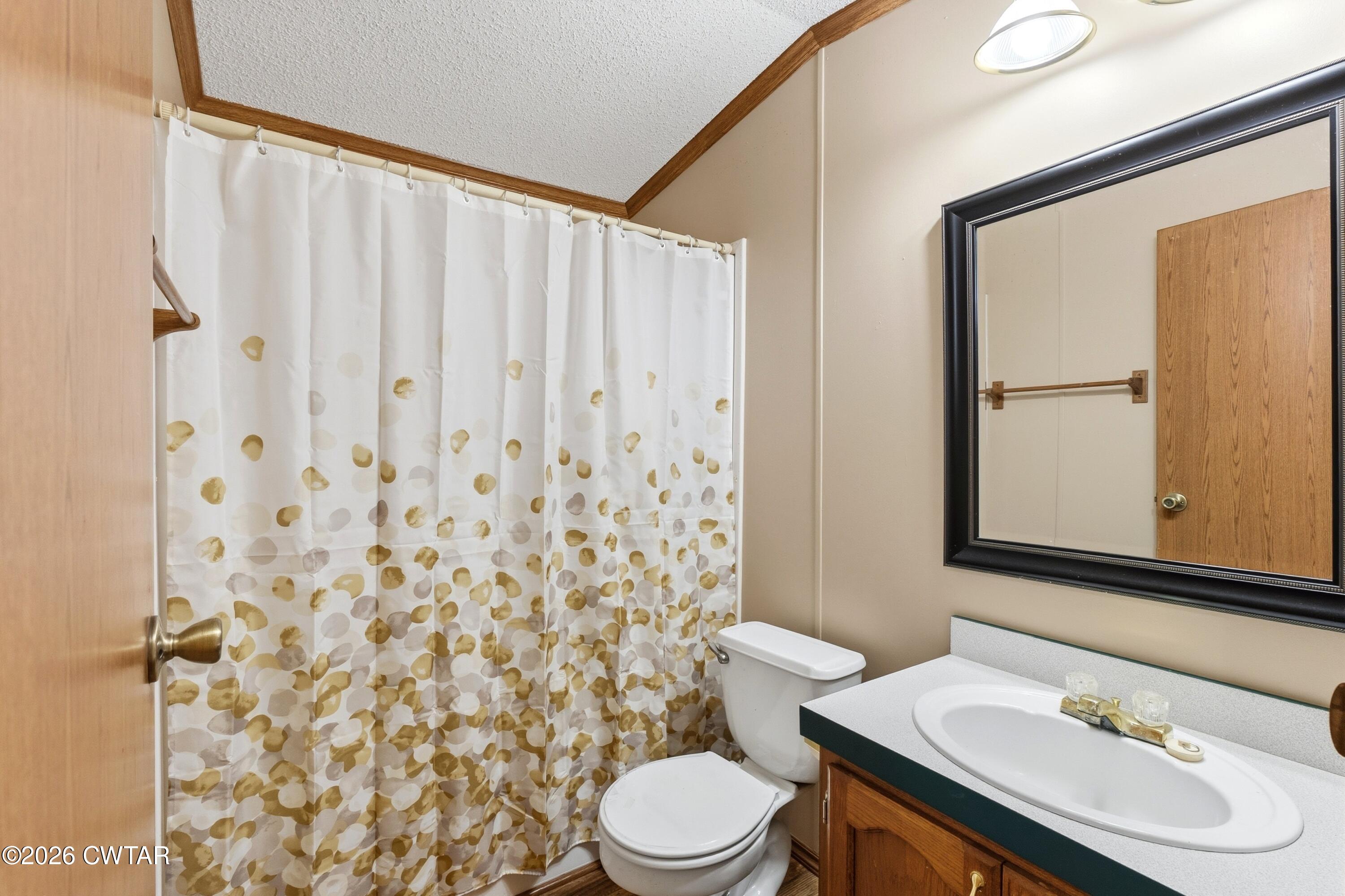 1444-1448 New Hope Road Big Sandy, TN 38221 - Photo 15 of 39 a bathroom with a sink a toilet and shower curtain