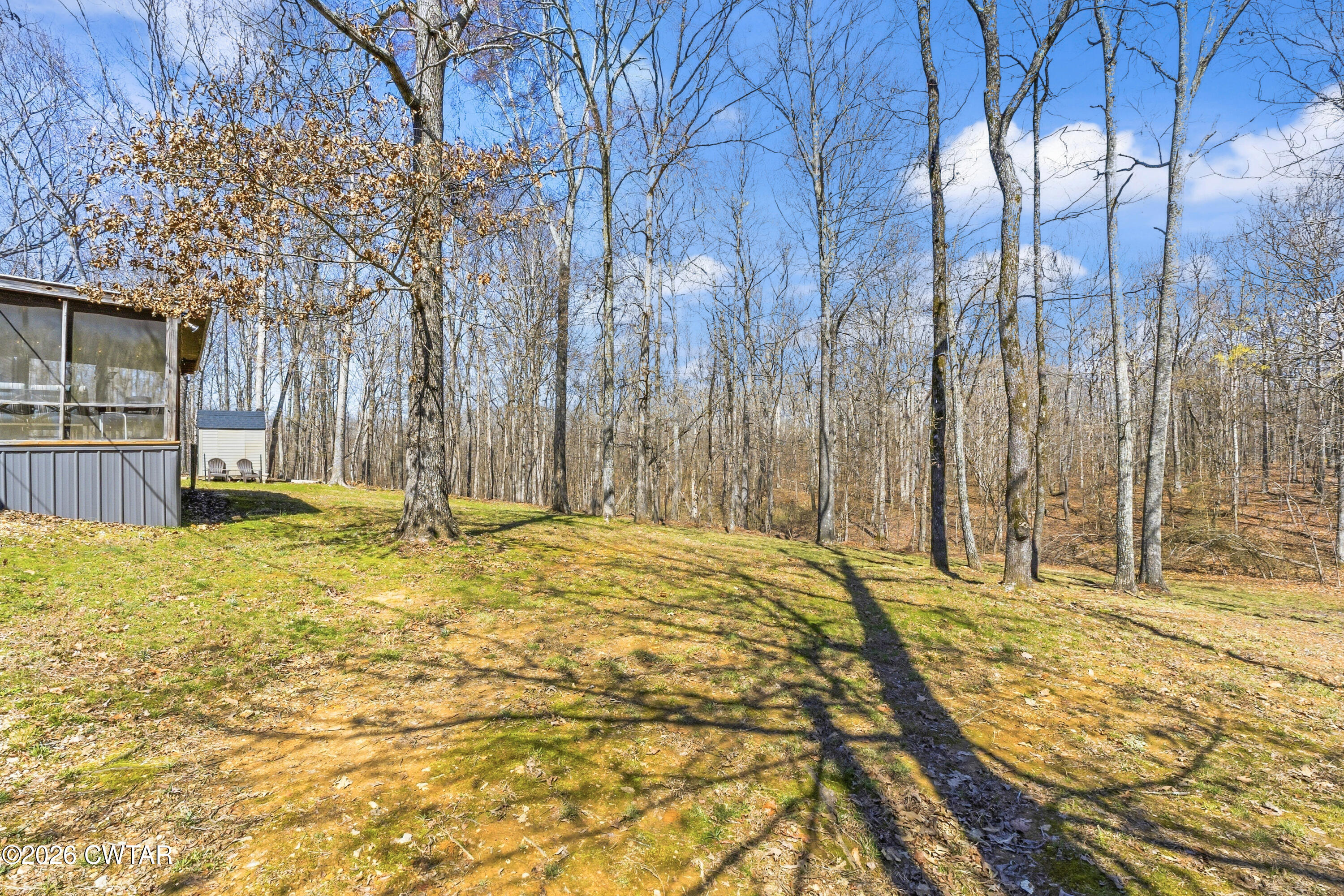 1444-1448 New Hope Road Big Sandy, TN 38221 - Photo 18 of 39 a swimming pool with trees in the background