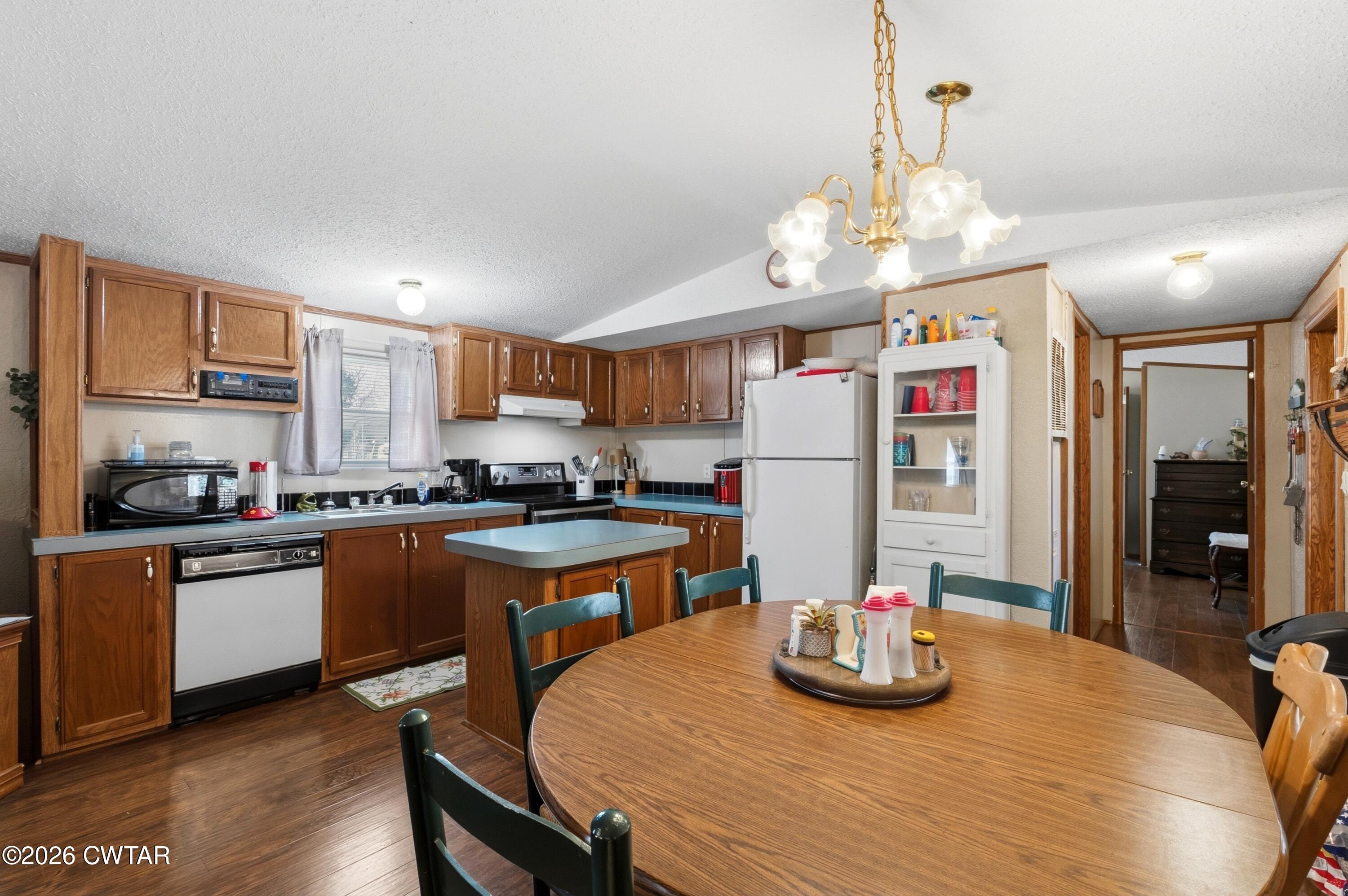 1444-1448 New Hope Road Big Sandy, TN 38221 - Photo 26 of 39 a kitchen with stainless steel appliances granite countertop a sink dishwasher and a refrigerator with wooden floor