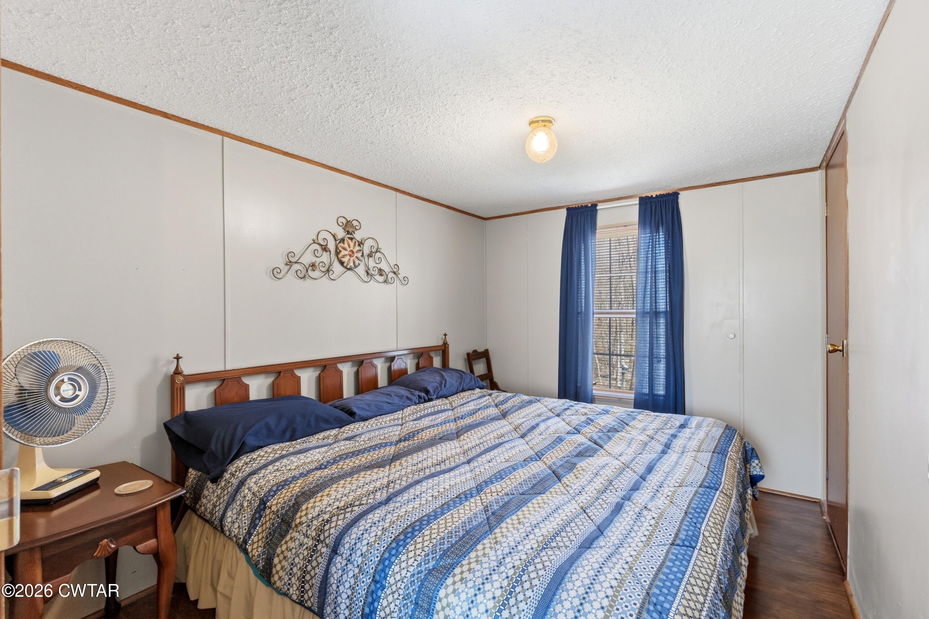 1444-1448 New Hope Road Big Sandy, TN 38221 - Photo 27 of 39 a bedroom with a bed and a chandelier