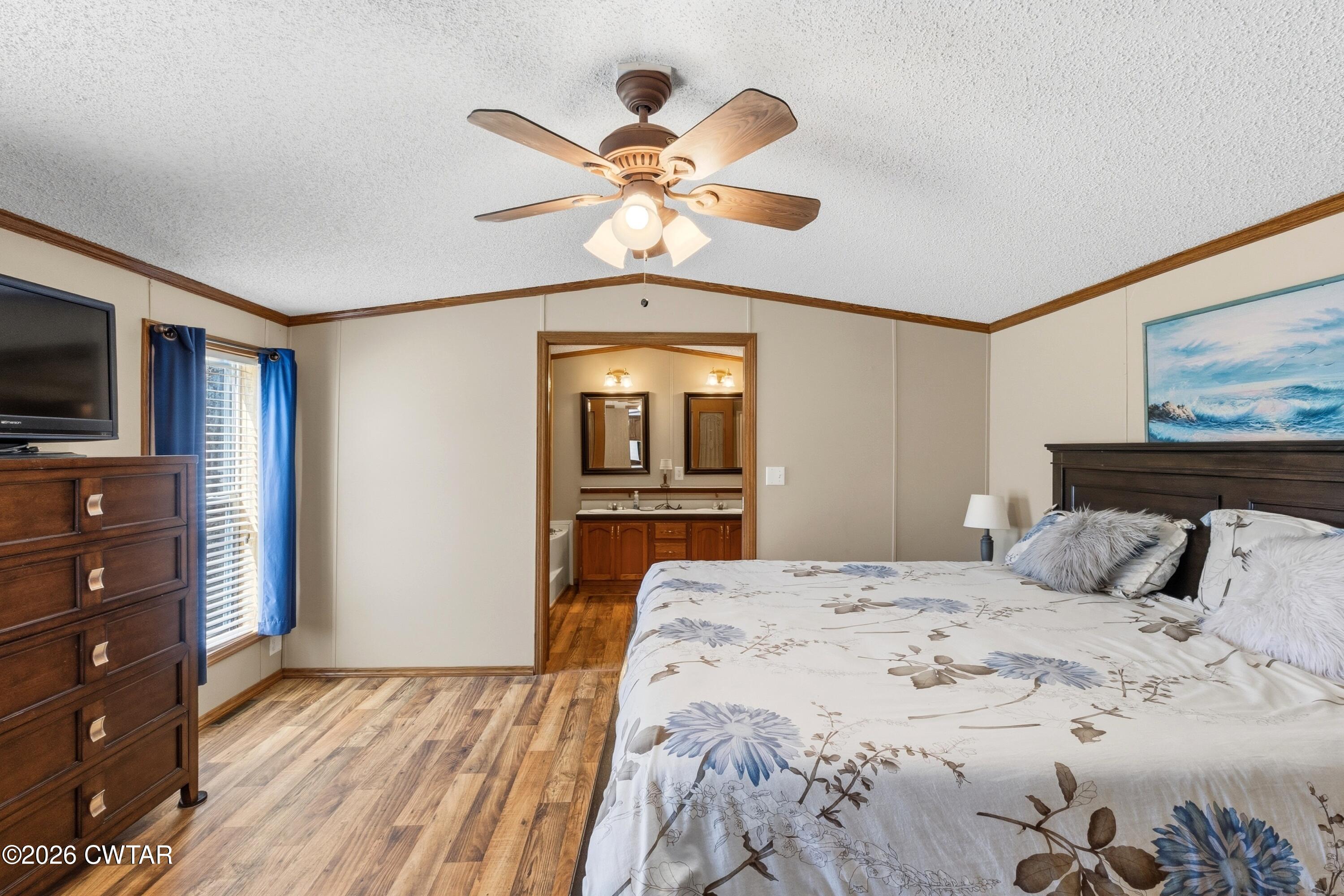 1444-1448 New Hope Road Big Sandy, TN 38221 - Photo 8 of 39 a bedroom with a large bed and a flat tv screen on dresser
