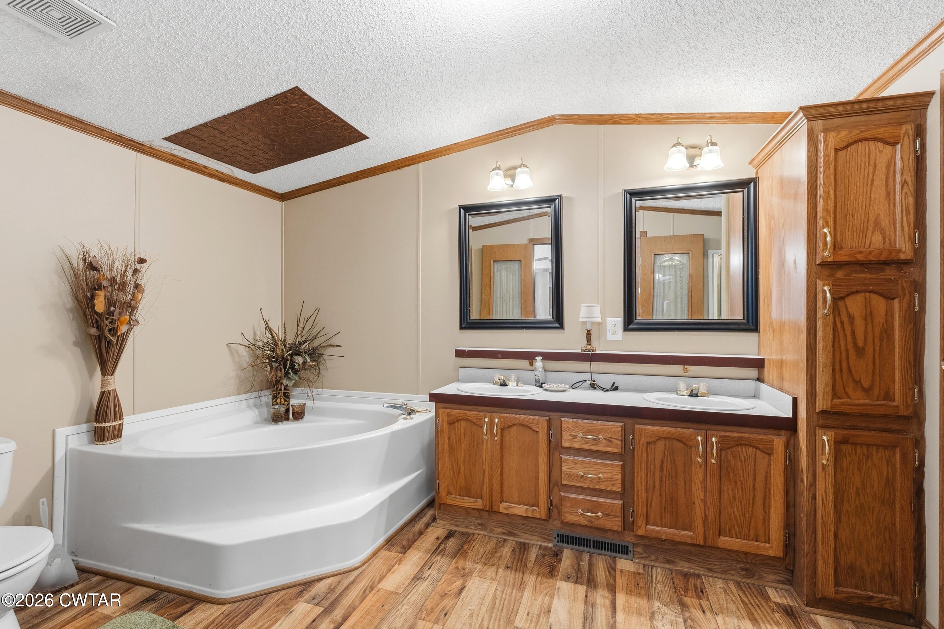 1444-1448 New Hope Road Big Sandy, TN 38221 - Photo 10 of 39 a bathroom with a double vanity sink mirror and bathtub