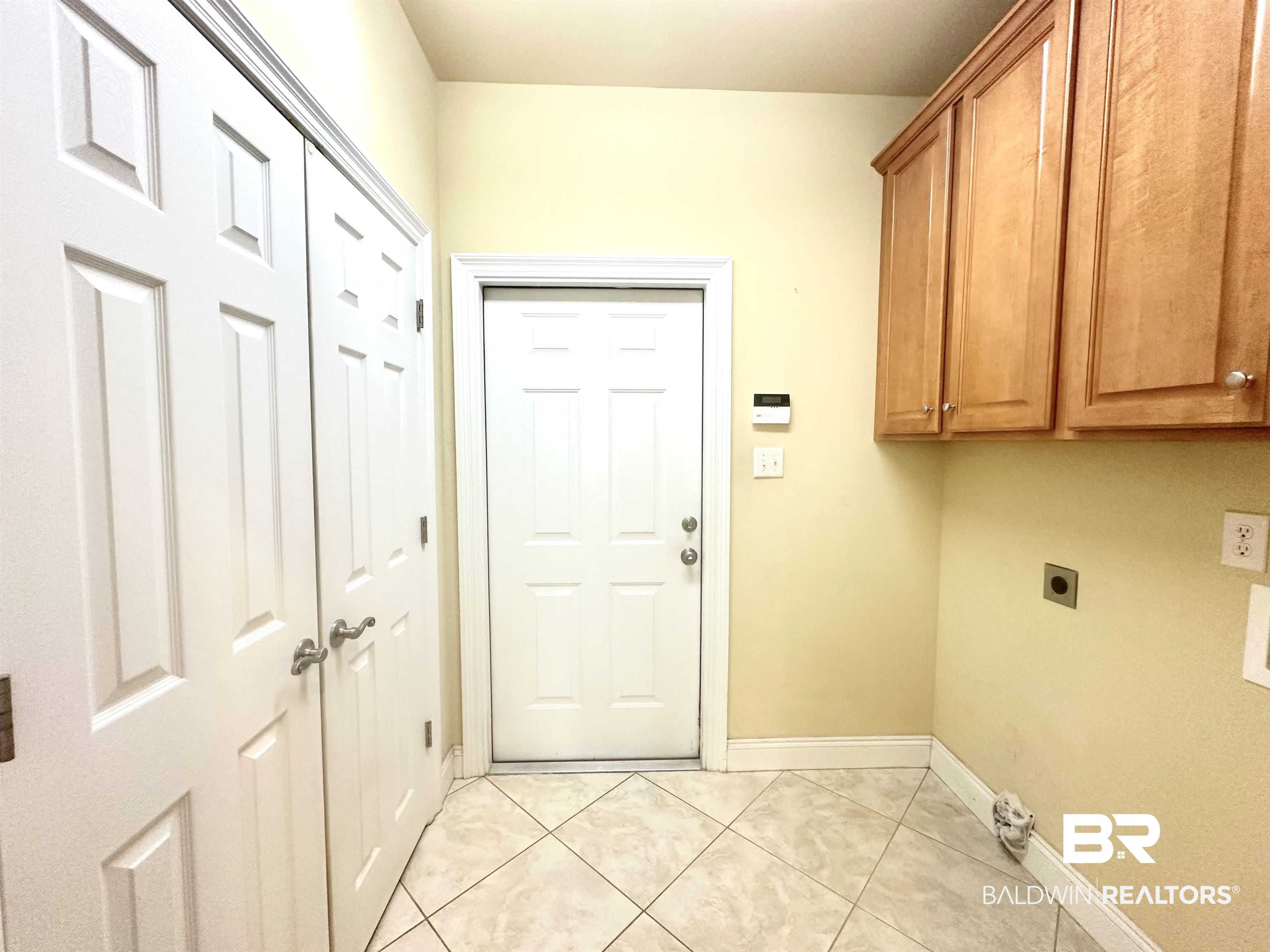 249 Hemingway Loop Foley, AL 36535 - Photo 19 of 33 Washroom featuring light tile patterned floors, electric dryer hookup, and cabinets