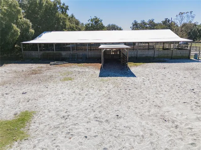a view of swimming pool with outdoor seating and trees in the background