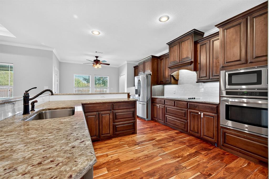 357 Pear Tree Lane Collinsville, TX 76233 - Photo 14 of 37 a kitchen with stainless steel appliances granite countertop a stove sink and cabinets