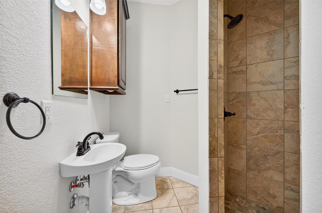 357 Pear Tree Lane Collinsville, TX 76233 - Photo 24 of 37 a bathroom with a toilet a sink and a mirror