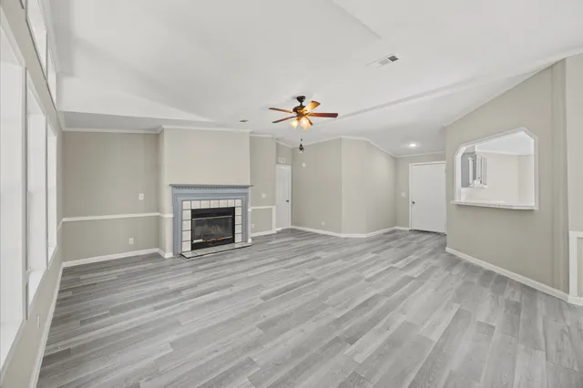 a view of an empty room with a fireplace and a window