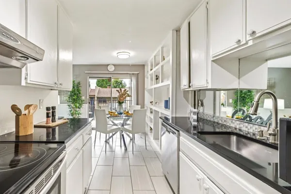 a very nice looking kitchen with granite countertop a large window and stainless steel appliances